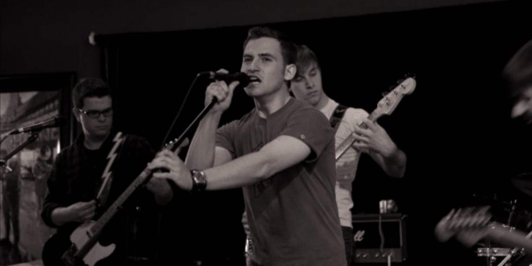A four-piece band playing on a small stage